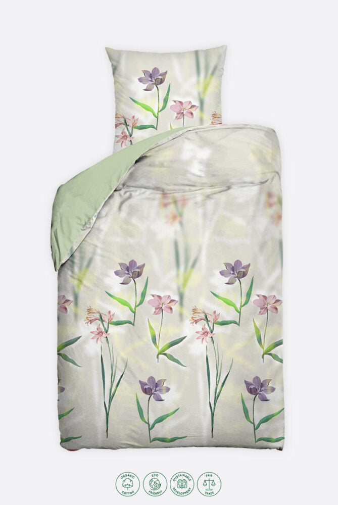 Bettwäsche-Set mit floralen Motiven auf hellem Hintergrund. Das Design zeigt violette, rosa und lachsfarbene Blumen mit grünen Stängeln und Blättern. Die Unterseite des Bettbezugs und das Laken sind in einem sanften Grünton gehalten.