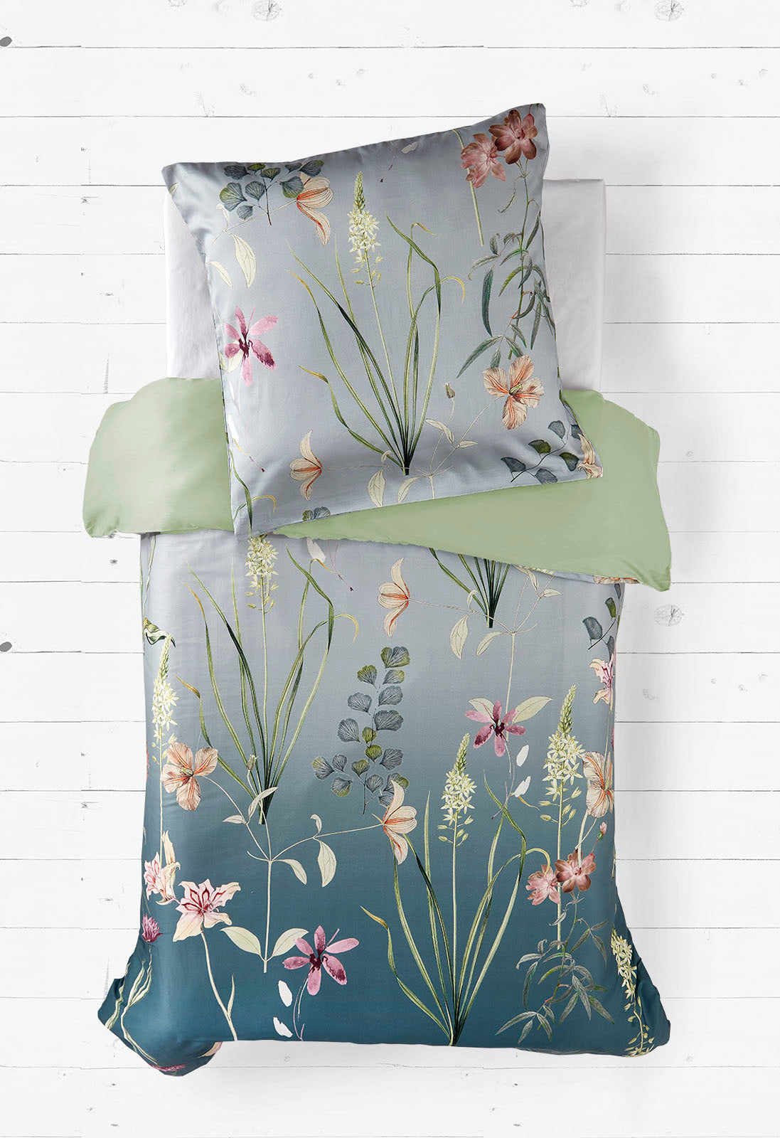 Das ist ein gemütliches und elegantes Bettwäscheset mit floralen Mustern auf einem tiefen Türkis-Hintergrund, kombiniert mit sanften, einfarbigen Pastelltönen.