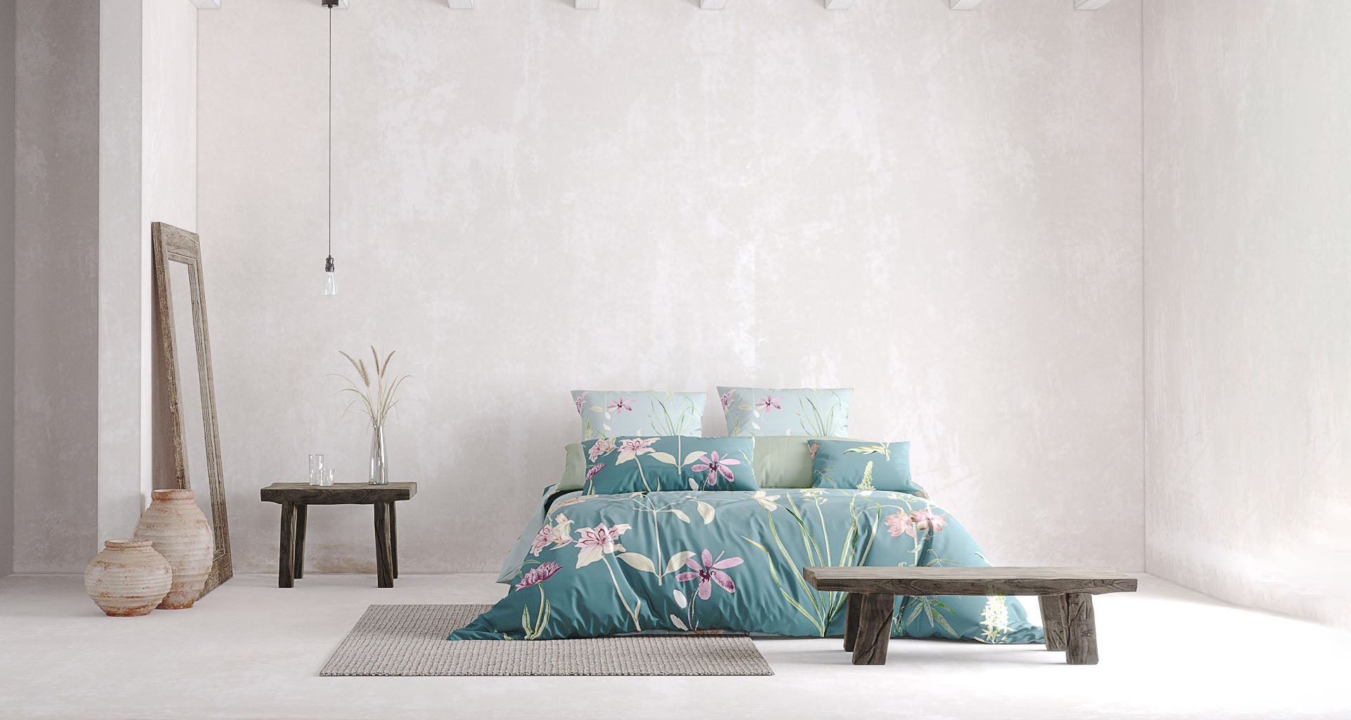 Ein minimalistisch eingerichtetes Schlafzimmer mit einer türkisfarbenen Bettwäsche, die mit zarten rosa und lila Blumen sowie grünen Blättern verziert ist. Das Bett steht vor einer hellen, strukturierten Wand. Links daneben lehnt ein rustikaler Holzrahmen-Spiegel an der Wand, daneben stehen zwei Keramikvasen auf dem Boden. Ein kleiner Holztisch mit einer Vase und zwei Gläsern befindet sich ebenfalls links vom Bett. Eine einzelne, minimalistische Hängelampe sorgt für dezente Beleuchtung. 